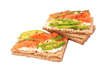 Fresh crunchy crispbreads with cream cheese, salmon, avocado and arugula isolated on white