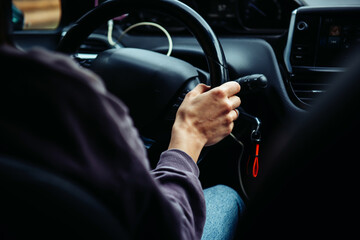 A woman holding the steering wheel tightly and driving a car. Traveling by car