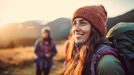 a young adult woman with a backpack on a mountain with a view of a valley and a mountain, nature and hiking, wanderlust, camping and hiking