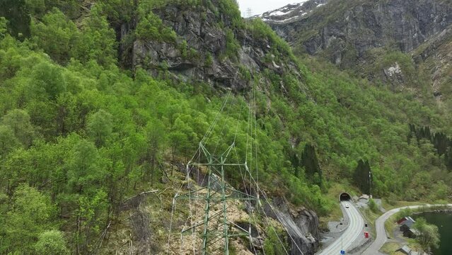 High voltage power lines disappearing into the vast mountains from Matre hydroelectric powerstation in western Norway
