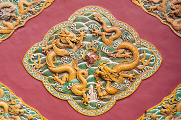 Two dragons are curvetting with a pearl on the wall of Forbidden City