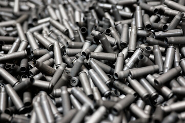 Bullet casings on dark background at armor production plant