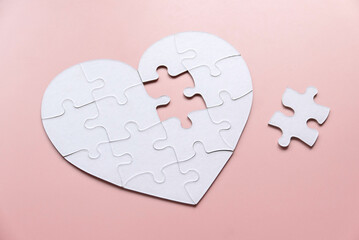 White puzzle heart with missing piece outside.