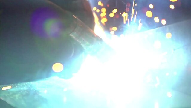 Closeup view of welding sparks and flame, flashing light, slow motion
