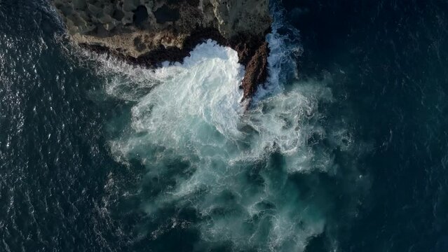 Waves breaking on rocks filme with a drone