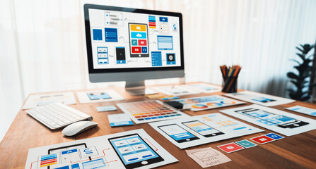 Digital and paper wireframe designs for web or mobile app UI UX display on laptop computer screen....