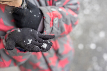 Snowflake on a black glove in the winter