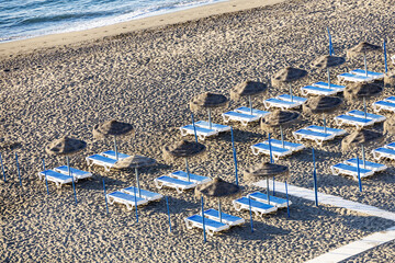 Fototapeta na wymiar Blue and white beach chairs in a row on a sandy beach