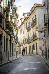 Fototapeta na wymiar Motorcycle driving down a cobblestone street in Europe