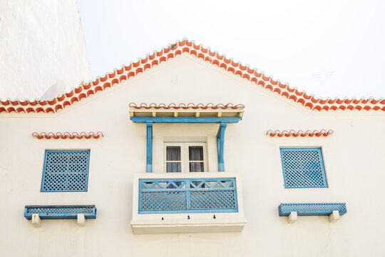 European White House With Orange Clay Tiles And Blue Shutters