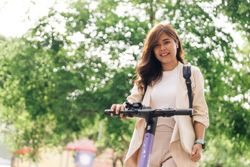 asian woman riding electric scooter in the park, lifestyle concept