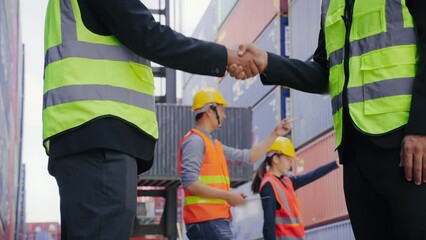 Close up foreman and worker shaking hand work success at terminal logistic area. Logistics and shipping concept