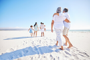 Big family, sea or old couple walking with kids in summer with happiness, trust or peace in nature. Grandparents, back view or senior man bonding with woman or children taking a walk on beach sand