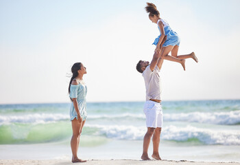 Mother, beach or father playing a girl in air on a family holiday, vacation or weekend break...