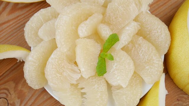 Peeled pomelo on a plate.