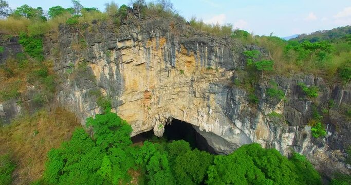 Aerial view of the trees in the waterfall crevices are lush green..The mountain separation creates a trench for waterfalls..a huge hole of cave covered waterfall in Thanlod Yai cave in Kanchanaburi.