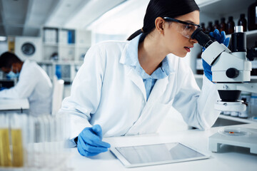 Microscope, digital tablet and woman scientist in a laboratory for science, research and data...