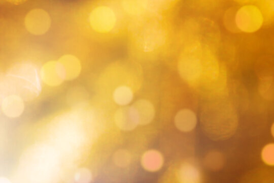 Blurred gold sparkles, defocused celebration lights.