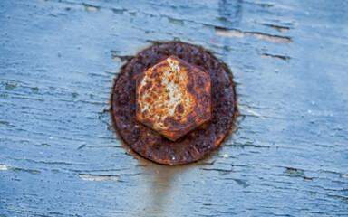 Fototapeta premium Close up of rusty round bolt and washer on weathered wooden.