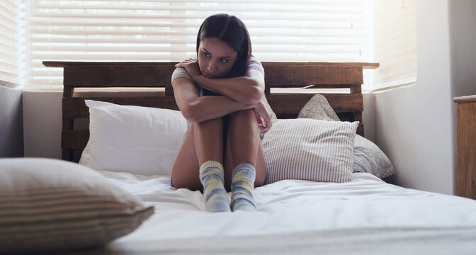 Depression, stress and woman in a bed thinking of problem, sad or mental health in her home. Anxiety, fear and female person with ptsd, grief or broken heart, lonely and paranoid in a bedroom