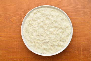 Potato powder in the white bowl on the rustic wooden table. Close-up. Top view.