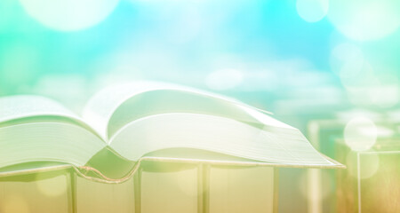 Open book close-up, blurred light background. Copy space.
