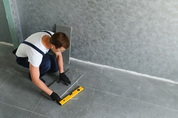 Fototapeta na wymiar industrial worker, handyman installing ceramic tiles.