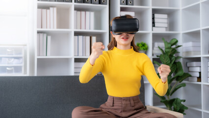 Smiling woman having fun using VR glasses playing game at home happily and enjoy virtual reality.