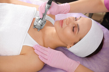 Naklejka premium Young woman undergoing cosmetic procedure in beauty salon. Microcurrent therapy