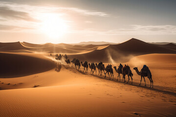 Camel caravan going through the Sahara desert in Morocco at sunset
