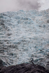 Close-up of Franz Josef glacier, Waiau, seen from glacial valley below, rough, rugged, blue ice and mountain, alps, South Island, New Zealand, NZ