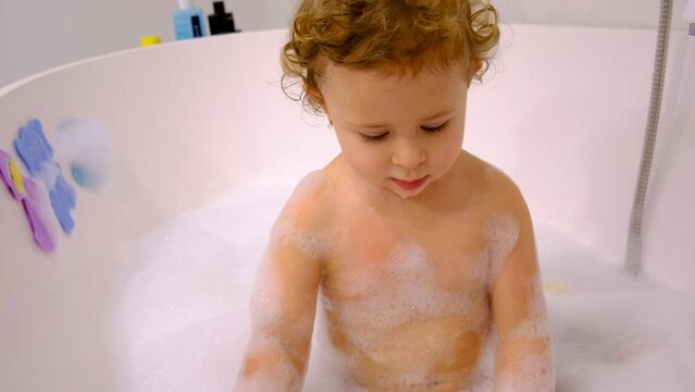A child bathes in a bubble bath. Selective focus. Baby.