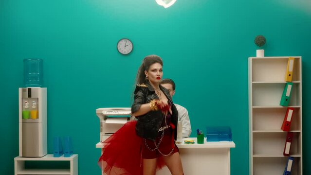 The female freak holds a sheet of paper with words BE YOURSELF and then scatters them. Woman in a black leather jacket with chains in the office. Feminism. Girl power. Advertising.