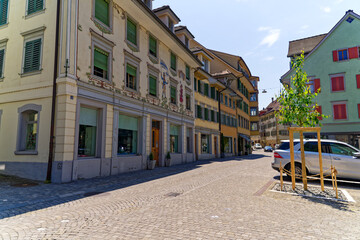 Naklejka premium Scenic view of facades of historic houses at the old town of Swiss City of Zug on a sunny spring day. Photo taken May 22nd, 2023, Zug, Switzerland.