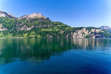 View of Lake Uri with beautiful mountain panorama and village Bauen on a sunny spring day. Photo taken May 22nd, 2023, Sisikon, Switzerland.