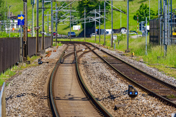 Railway tracks with railway switch at railway station of Swiss village Sisikon on a sunny spring...