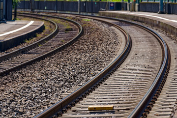 Fototapeta na wymiar Close-up of railway tracks with curve at railway station of village Sisikon on a sunny spring noon. Photo taken May 22nd, 2023, Sisikon, Canton Uri, Switzerland.