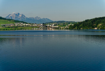 Fototapeta premium Scenic view of Swiss Lake Zug on a sunny spring day with famous Mount Pilatus in the background. Photo taken May 22nd, 2023, Lake Zug, Switzerland.