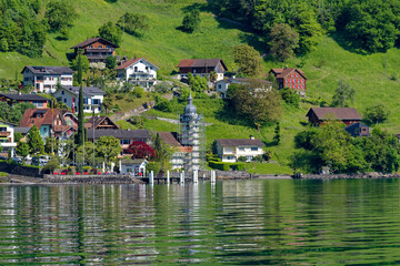 Scenic view of village Bauen seen from passenger ship on Lake Lucerne on a sunny spring day. Photo taken May 22nd, 2023, Bauen, Canton Uri Switzerland.