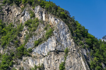 Scenic view of rock with cliff at lakeshore of Lake Lucerne on a sunny spring day. Photo taken May 22nd, 2023, Sisikon, Switzerland.