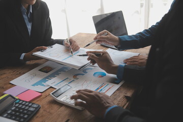 Financial analysts analyze business financial reports on a digital tablet planning investment project during a discussion at a meeting of corporate showing the results of their successful teamwork.