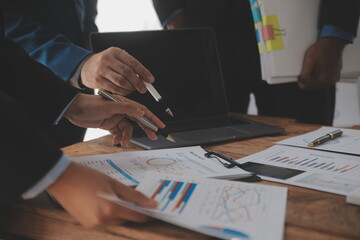 Financial analysts analyze business financial reports on a digital tablet planning investment project during a discussion at a meeting of corporate showing the results of their successful teamwork.