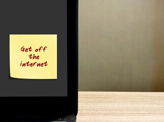 Laptop in copy space background with stick note written GET OFF THE INTERNET , concept of stop...