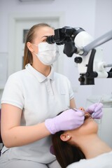 professional dentist examination patient with microscope at the office