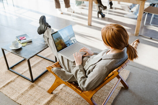 High angle view of businesswoman using laptop while sitting in chair at office