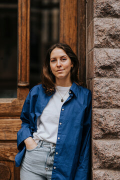 Portrait of non-binary person with hand in pocket leaning on wall