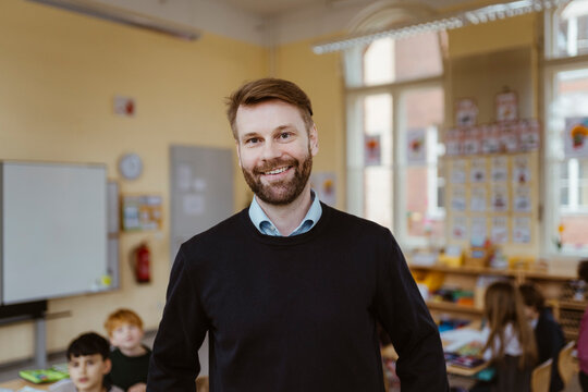Portrait of smiling mature male teacher in classroom