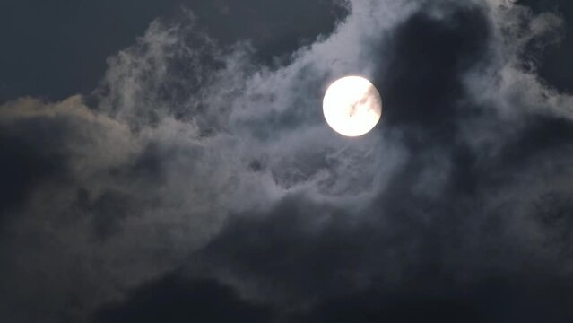 Fast speed time lapse scene of full moon emerge from cloud moving pass after covering it in the night, black smoke blinding lunar, spooky environment, mysterious cloudy sky for horror movie background