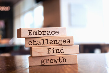 Wooden blocks with words 'Embrace challenges, find growth'.