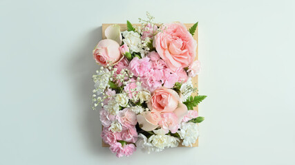 Obraz na płótnie Canvas Wooden crate full of pastel colors flowers with pink rose and carnation on white background